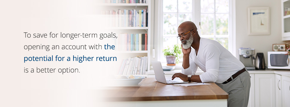 Man working on his laptop while standing in a kitchen