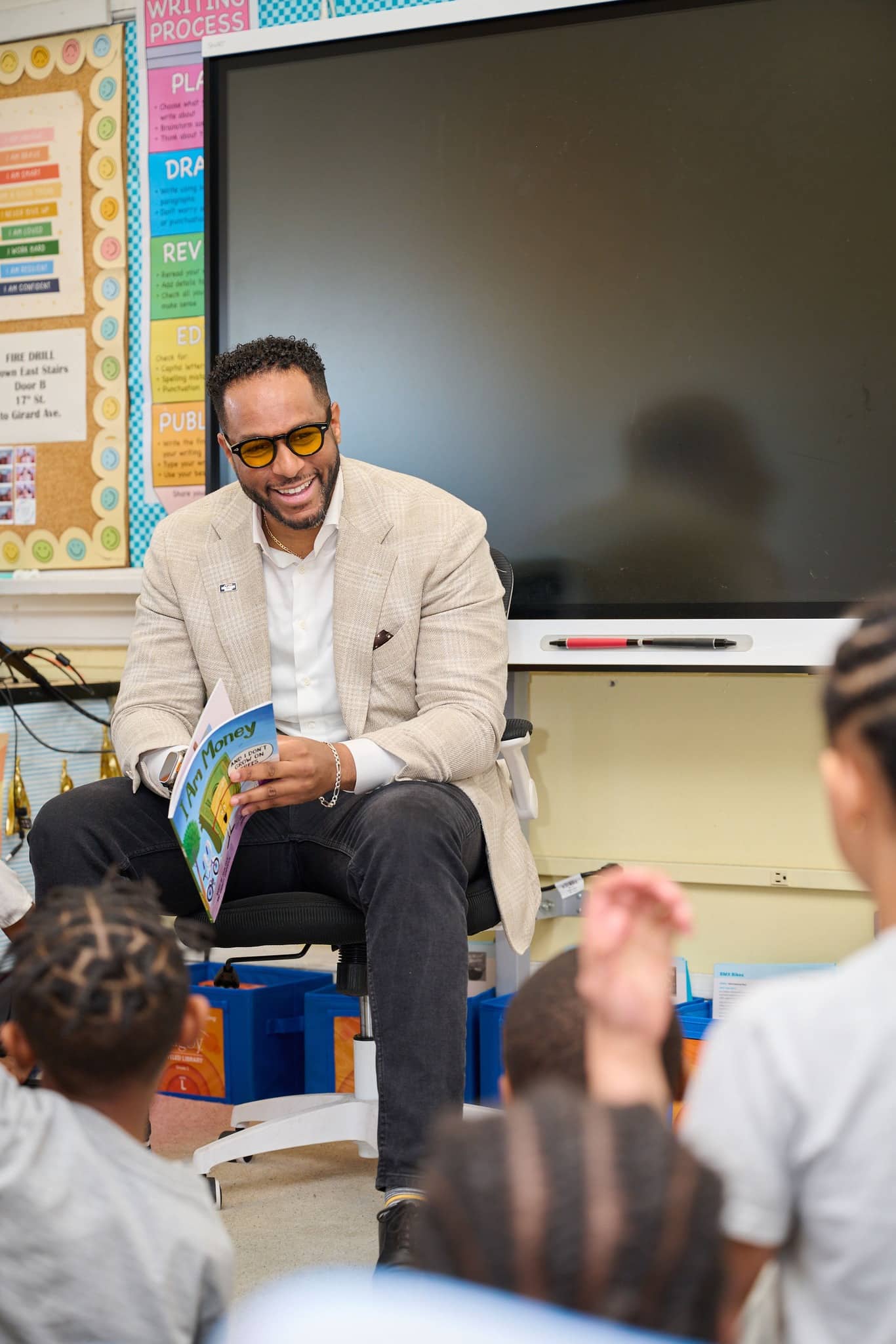 Abe Ibrahim, Regional President of Mid Penn Bank, reading a money-themed children’s book aloud to students in a classroom